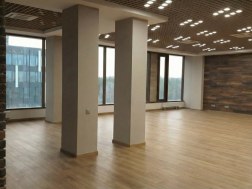 Ремонт офиса open space: зал с колоннами, панорамными окнами и деревянным полом